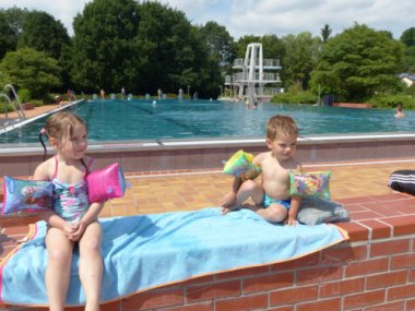 Schwimmbad zwei Kinder mit Schwimmflügel sitzen auf der Bank im Freibad in Contwig